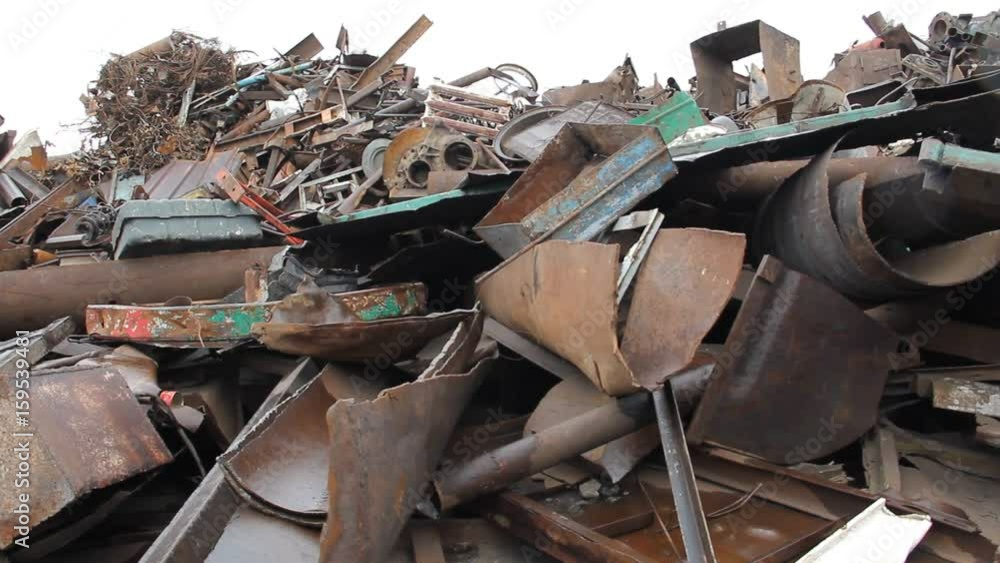 Sorting and loading of scrap metal. / Excavator is loading scrap metal junk into a bin at a garbage dump or recycling center. Sorting and loading of scrap metal. / Excavator is loading scrap metal junk into a bin at a garbage dump or recycling center.