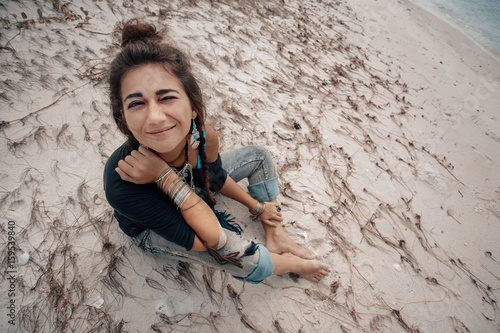 Beautiful young woman sitting on the beach photo