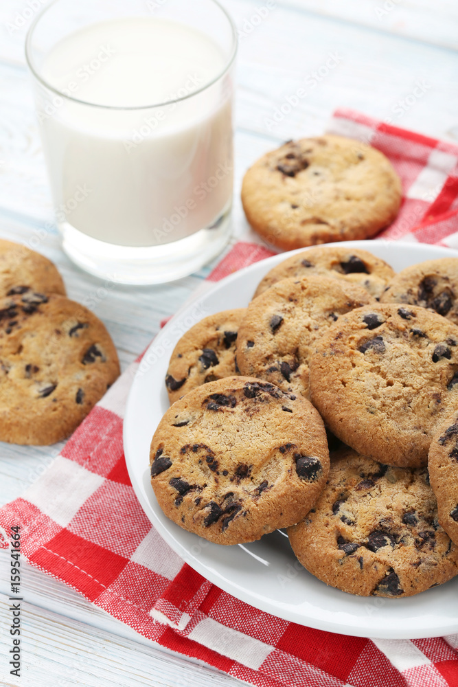 Chocolate chip cookies with glass of milk on white wooden table Chocolate chip cookies with glass of milk on white wooden table