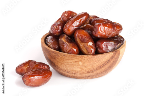 Dates in a wooden bowl isolated on white background