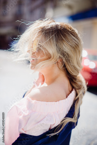 Blonde woman in suglasses looks up in a sunny sky