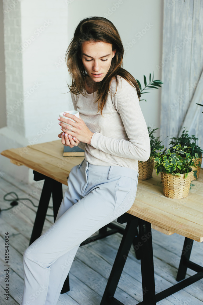 young woman relaxing at home with cup of coffee young woman relaxing at home with cup of coffee