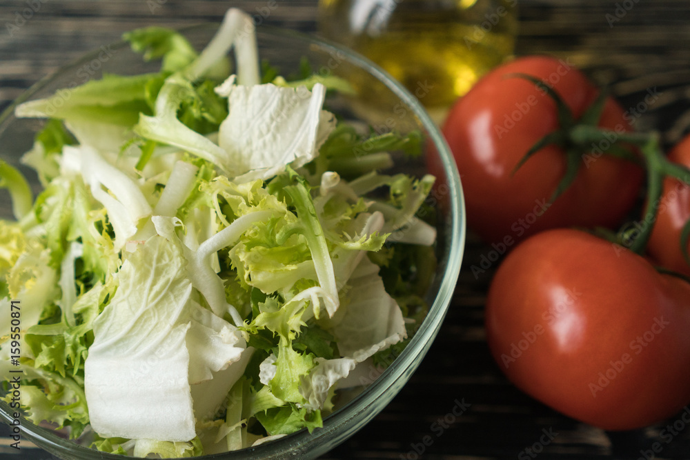 Healthy veggie salad ingridients. Tomato, lettuce and olive oil.