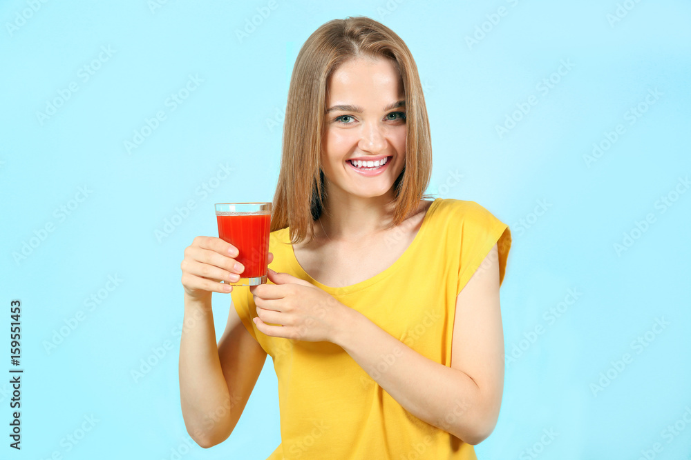 Young beautiful woman with a glass of fresh juice on grey background Young beautiful woman with a glass of fresh juice on grey background