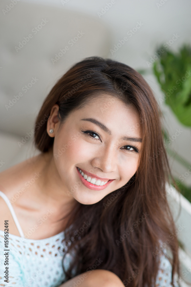 Smiling beautiful asian woman relaxing in the morning sitting indoors. Smiling beautiful asian woman relaxing in the morning sitting indoors.