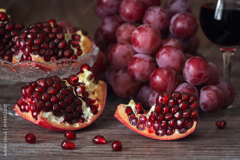Juicy pomegranate with red grape and red wine. Still life with pomegranate. Juicy pomegranate with red grape and red wine. Still life with pomegranate.