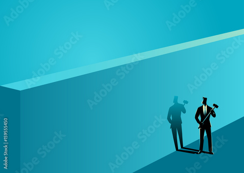 Businessman standing near wall with a hammer