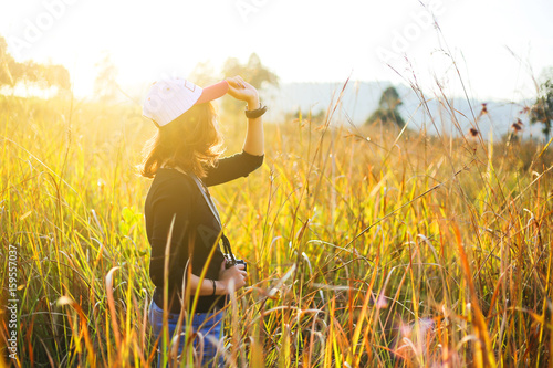 Portrait of a beautiful young Woman traveler looks with camera enjoying nature summer at sunset or sunrise outdoors