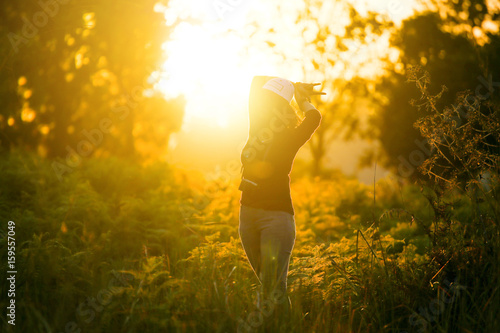 Portrait of a beautiful young Woman traveler looks with camera enjoying nature summer at sunset or sunrise outdoors