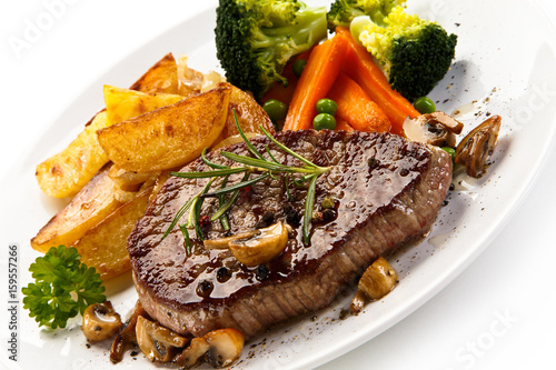 Grilled beefsteak with broccoli and carrot on white background