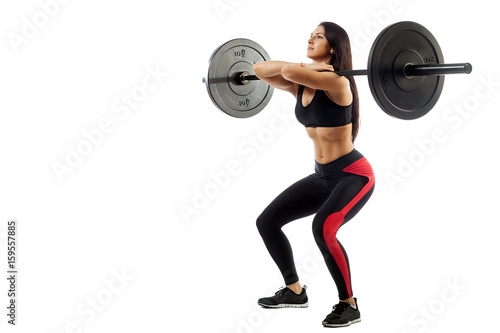 Young athletic brunette woman doing squat with a barbell, loki in front of him, position of a half-squat on a white isolated background