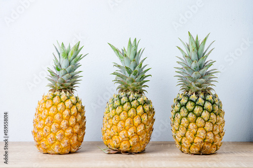 Ripe pineapples on a wooden table background.