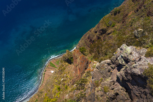 Green Madeira coast with azure water and blue sky
