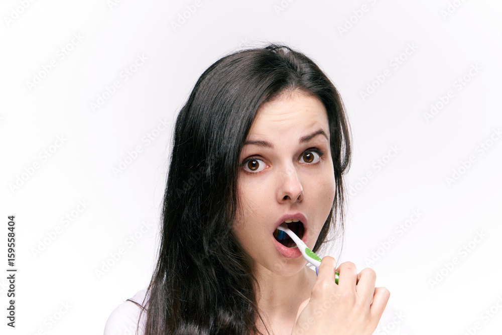 Woman brushing her teeth and tongue on isolated background Woman brushing her teeth and tongue on isolated background
