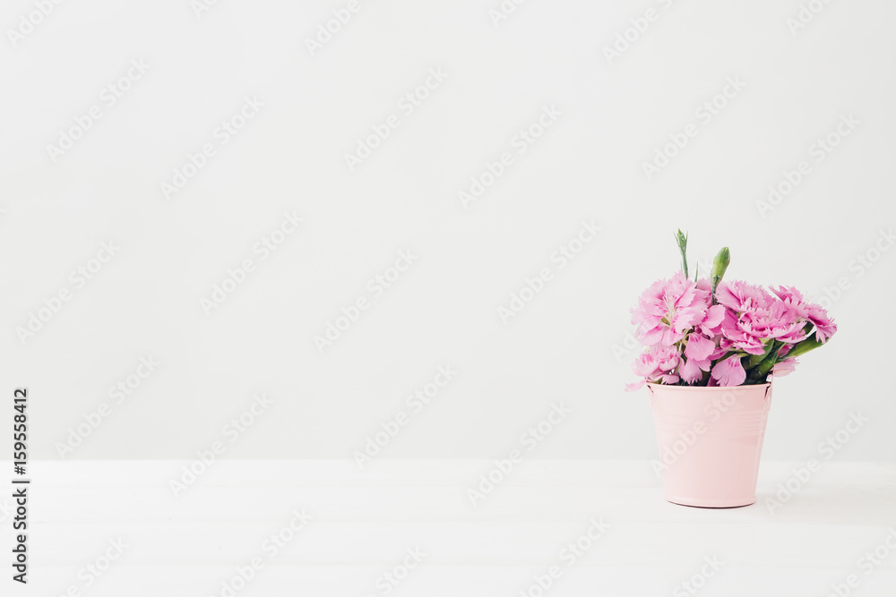 bouquet of pink Carnationflowers in vase on white table. Empty space for text