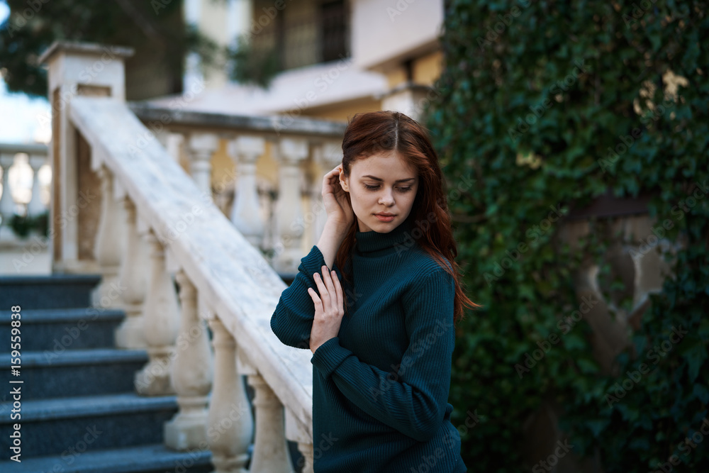 Woman leaning on a railing, woman on a background of stairs