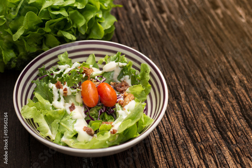 Healthy salad bowl with tomatoes, Beacon, on wooden background. Food and health