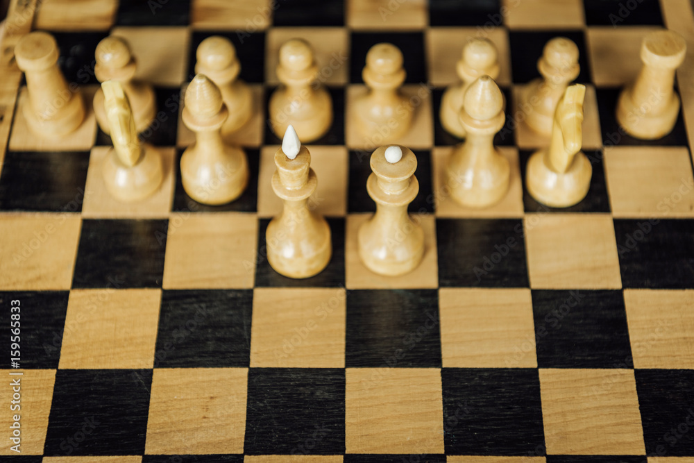 High angle view of part of a chess board with chess king and queen staying in front of white chess pieces High angle view of part of a chess board with chess king and queen staying in front of white chess pieces