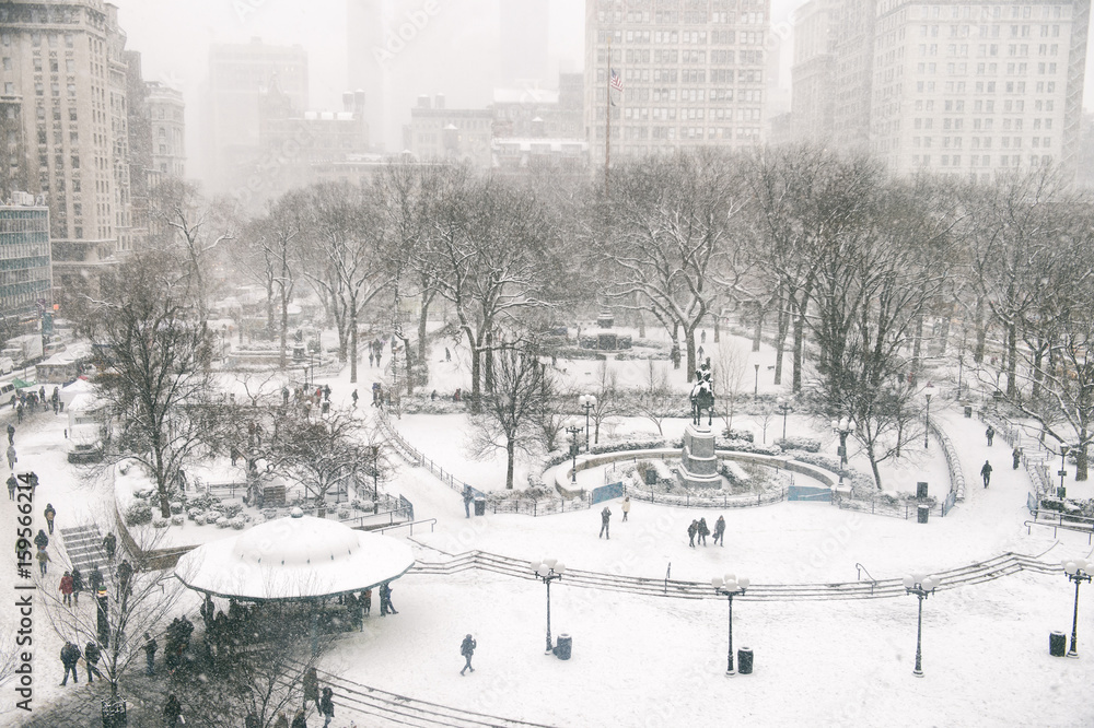 Snowy winter scene with trails left by pedestrians in the snow in Union Square as a blizzard overtakes New York City