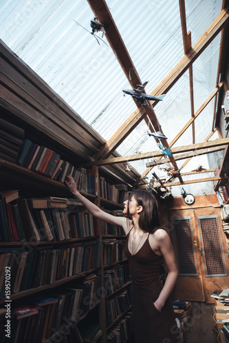 Young woman searching book in library