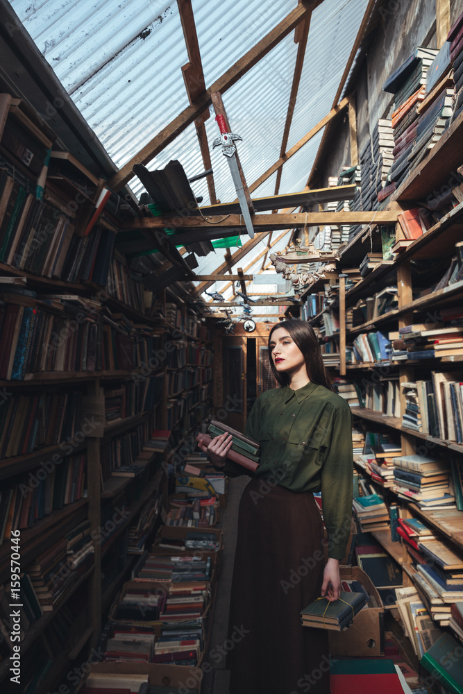 Girl standing in library with books