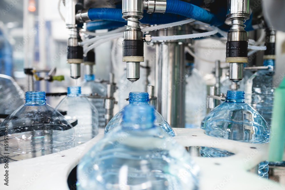 Industrial factory indoors and machinery. Robotic factory line for processing and bottling of pure spring water into canisters and bottles. Selective focus. Short depth of field. Industrial factory indoors and machinery. Robotic factory line for processing and bottling of pure spring water into canisters and bottles. Selective focus. Short depth of field.