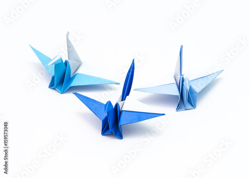 Leadership concept with origami bird leading among blue.