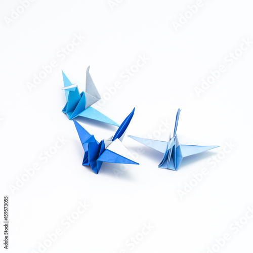 Leadership concept with origami bird leading among blue.