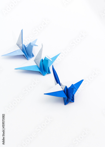 Leadership concept with origami bird leading among blue.