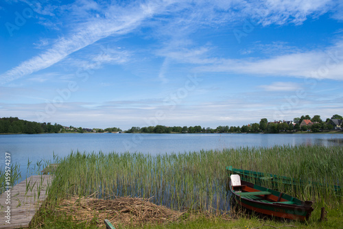 Concept of tranquil country life. Green boat in the lake on sunny summer day in Lithuania  Trakai. Excellent for flyer  post card  advertising  blog  instagram  calendar  notebook  wallpaper