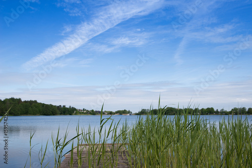 Trakai lake on summer day in Lithuania. Concept of tranquil country life, eco friendly tourism, camping. Excellent for flyer, post card, advertising, blog, instagram, calendar, notebook, wallpaper