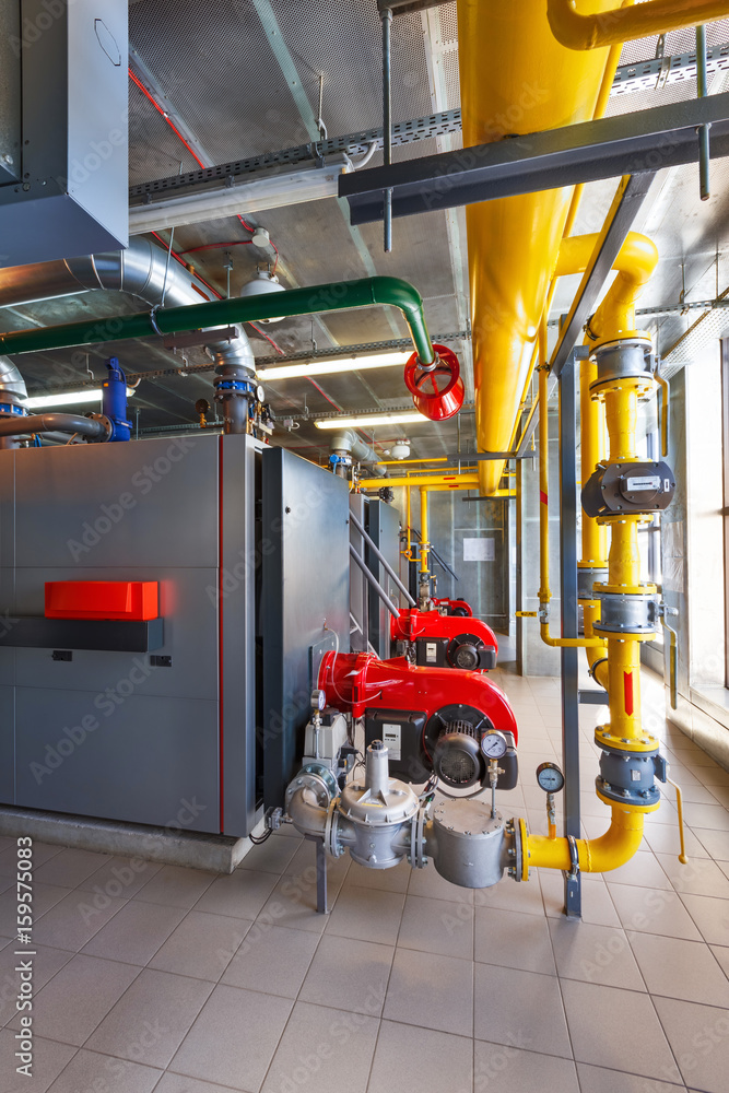 The interior of a modern gas boiler house with boilers, pumps, valves and a multitude of sensors The interior of a modern gas boiler house with boilers, pumps, valves and a multitude of sensors