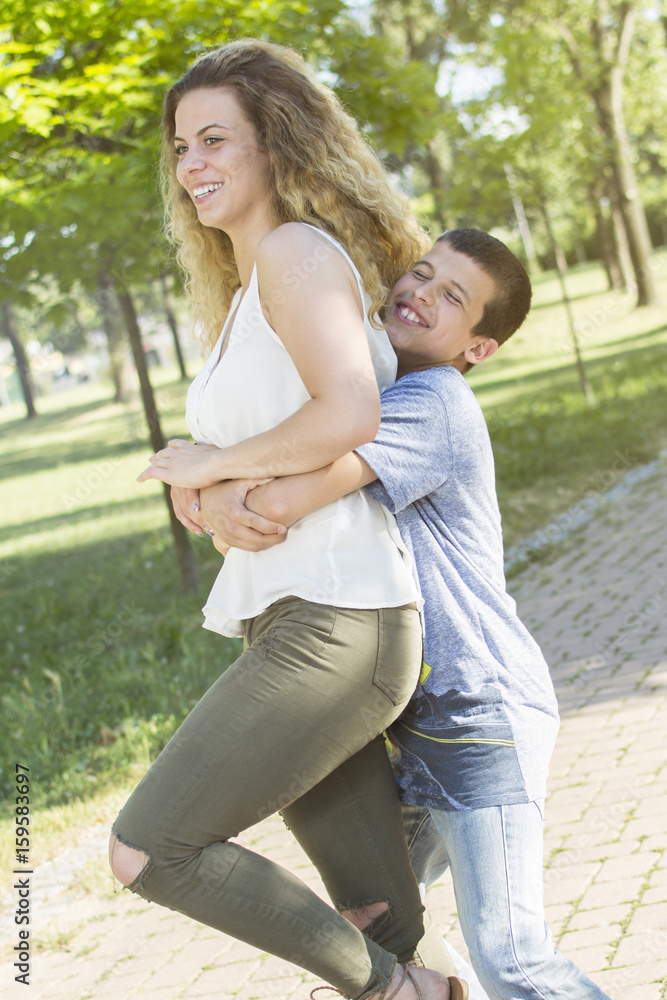 Little brother hugging his sister. Siblings having fun at the park. Little brother hugging his sister. Siblings having fun at the park.