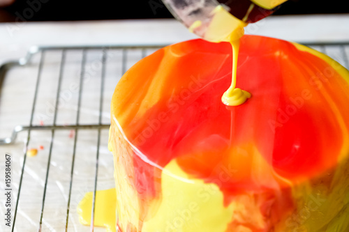 Fotografi The process of casting the mirror glaze on a cake round session