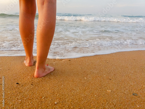 Closeup on woman walking on sandy beach outside background. Natural surface footprints