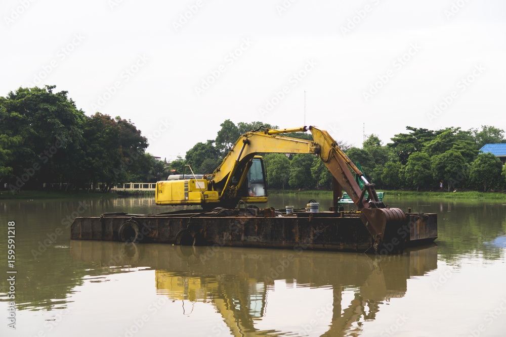 Yellow Excavator on lagoon Yellow Excavator on lagoon