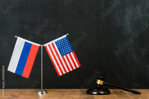 American and Russian flag on flagpole photo