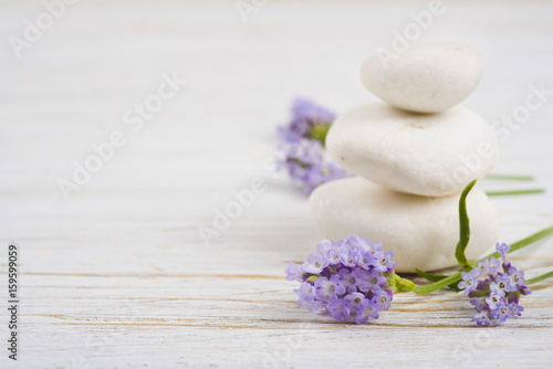Stones and twigs with lavender flowers on wooden table