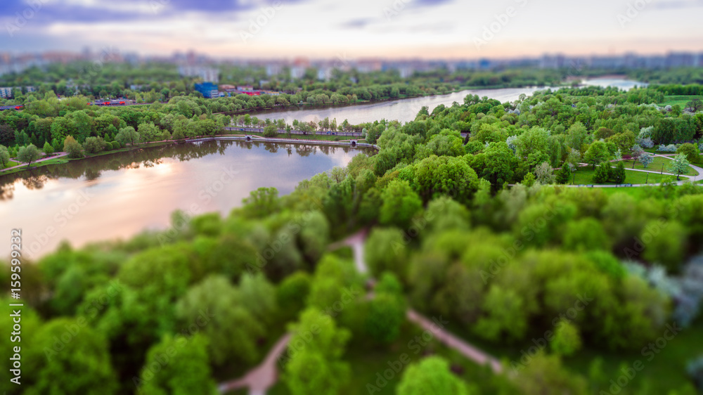 Aerial view of Tsritsyno lake - Moscow city in Russia. Park. Multi-storey buildings in the background. Sunset.