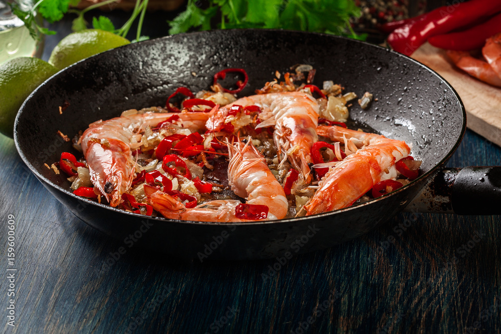 Shrimps roasted on frying pan with onion, garlic and chili Shrimps roasted on frying pan with onion, garlic and chili