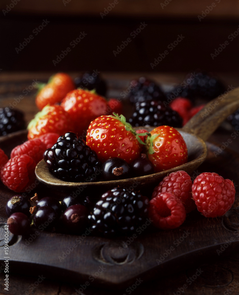 Still life of strawberries, raspberries and blackberries on spoon Still life of strawberries, raspberries and blackberries on spoon