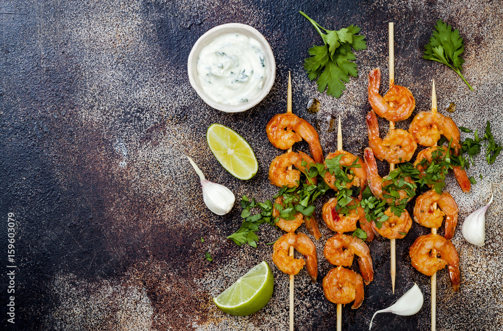 Grilled spicy lime shrimp skewers with creamy avocado garlic cilantro sauce. Top view, overhead, flat lay, copy space