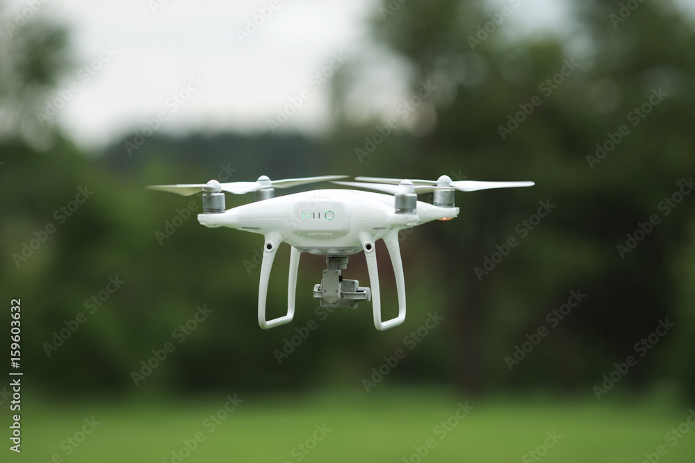 Closeup shot of a small drone flying above green lawn Closeup shot of a small drone flying above green lawn