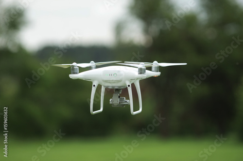 Closeup shot of a small drone flying above green lawn