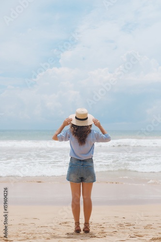 Girl in a hat on the beach 