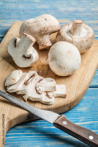 Sliced raw mushrooms on a chopping board.