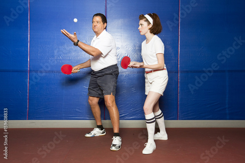 Table tennis coach teaching student to serve photo