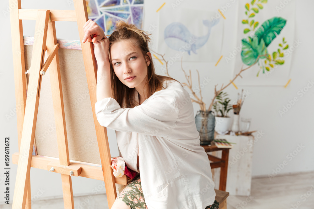 Attractive young caucasian lady painter at workspace Attractive young caucasian lady painter at workspace