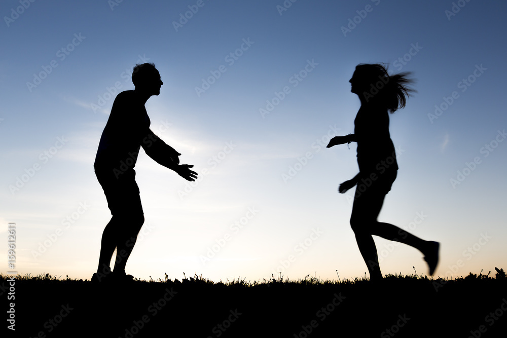 silhouette of romantic lovers with sunset on the back silhouette of romantic lovers with sunset on the back