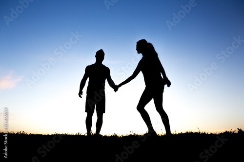 silhouette of a couple dancing against blue sky